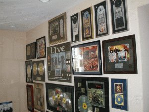 Musician's wall of art and awards hung by the professional art installation company - Art Hangers
