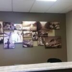 collage of framed canvas pictures behind work desk - Art Hangers