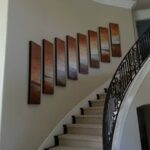 Professional art installation of canvas wall art descending with the stairs and installed Art