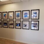 framed photos hung orderly on office wall - Art Hangers Installation 